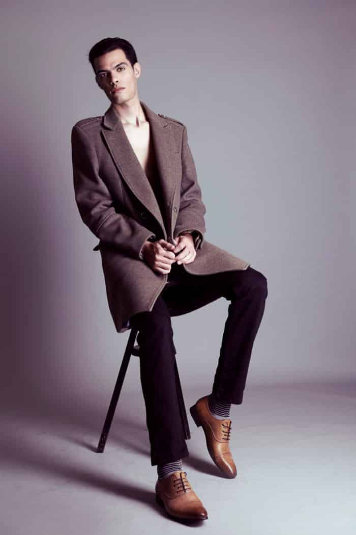 Hamza assis sur un tabouret pour une photo en pied destinée à son test mannequin