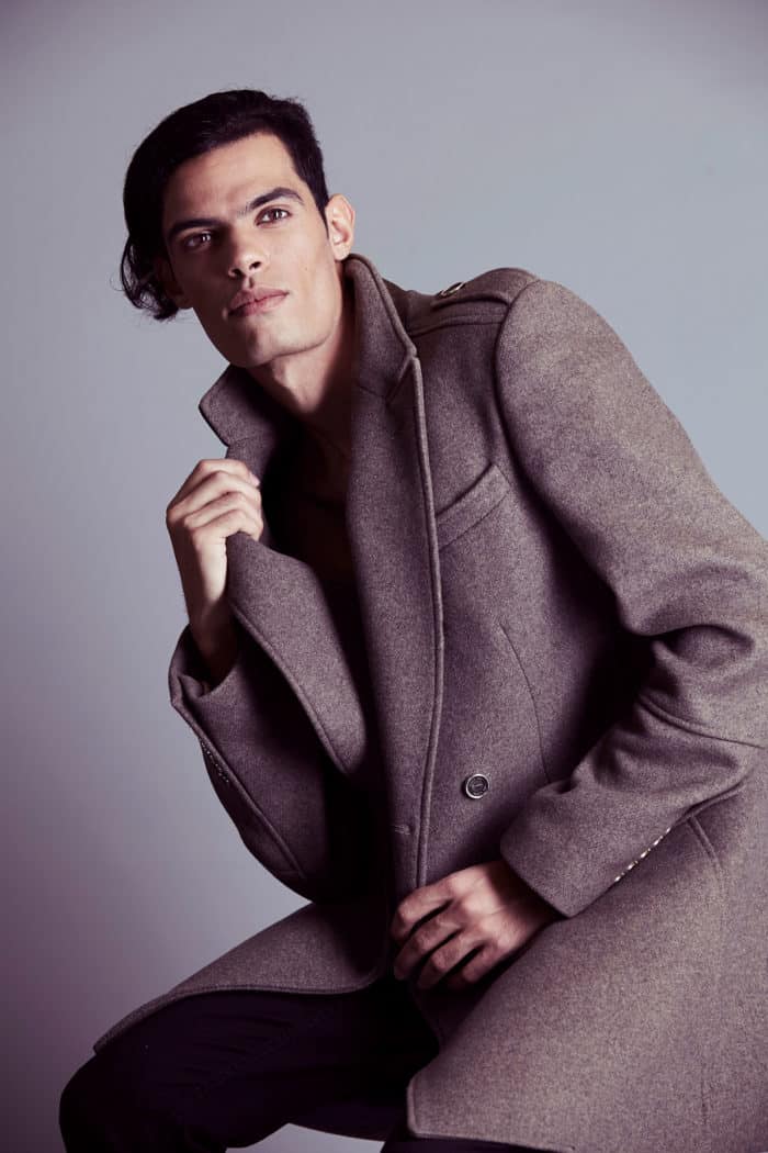 Pose mode de Hamza jouant avec le col de son manteau pendant le test photo